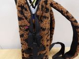 a brown and black animal print bag on a wooden table
