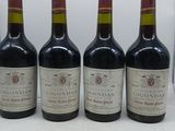 quatre bouteilles de vin sont alignées sur une table