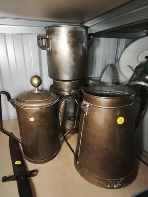several pots and pans are sitting on a shelf in a kitchen