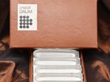 a brown box with six white plates in it on a brown cloth