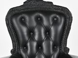 a black leather chair with buttons on the back of it