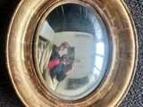 un miroir sur le mur reflétant une femme en train de prendre une photo