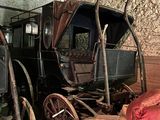 a horse drawn carriage in a room with a brick wall