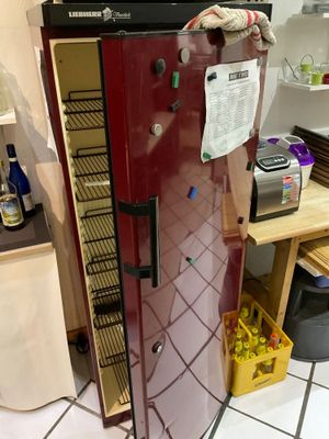 a red refrigerator that is in a kitchen with a microwave on top of it