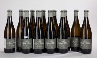 six bottles of wine are lined up in a row on a white surface