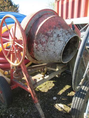 une bétonnière posée dans l'herbe à côté d'un camion