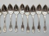 six silver spoons are lined up in a row on a table