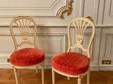 pair of chairs with red velvet upholstered seats on a parquet wood floor