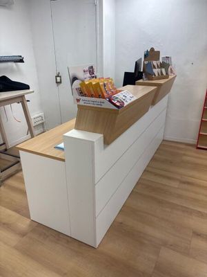 un comptoir blanc avec un plan de travail en bois et une échelle rouge en arrière-plan