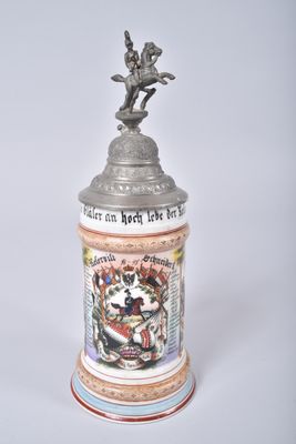 a beer mug with a statue on top of it