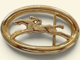 a gold brooch with a horse and rider on it