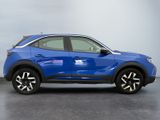 a blue car parked in a garage next to a white wall