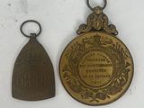 two medals that are on display on a white surface