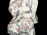 statue d'une femme tenant un instrument de musique sur fond noir