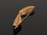 an image of a gold and diamond leaf broochle