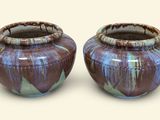 two vases sitting next to each other on a white surface