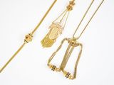 trois colliers en or et un collier orné d'un pendentif représentant un visage