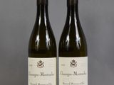 deux bouteilles de vin posées sur une table l'une à côté de l'autre
