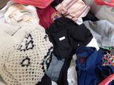 a pile of clothes that is sitting on a bed