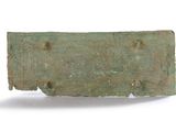 an old bronze plaque with holes in it on a white surface