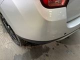 a white car parked in a garage with its lights on