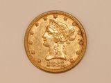 a close up of a gold coin with a woman ' s head on it
