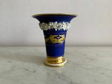 un vase bleu orné de motifs dorés, posé sur une table