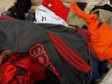 a suitcase full of clothes and clothes sitting on the floor