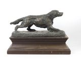 statue en bronze représentant un chien sur un socle, sur fond blanc