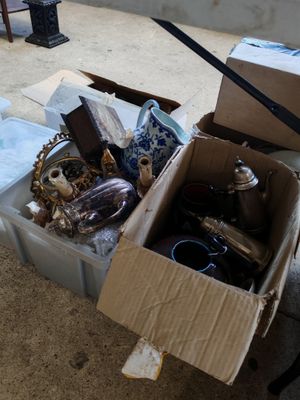 une boîte remplie d'objets hétéroclites posée sur le sol