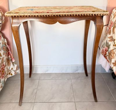 une petite table en bois recouverte d'une nappe à motifs floraux