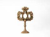 une horloge dorée posée sur un socle, sur fond blanc