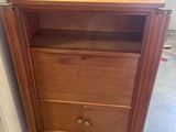 a small wooden cabinet with a drawer on top of it