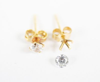 a pair of gold and diamond earrings on a white background