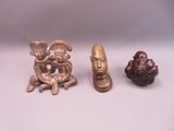 three figurines of different shapes and sizes on a white surface