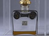 a bottle of perfume with a clock on top of it