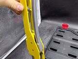 a hand that is holding a clamp in the back of a truck