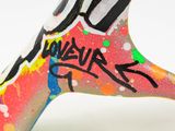 brightly colored hand painted giraffe with graffiti on it ' s face