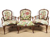 Trois chaises dotées de coussins rembourrés à motifs floraux sont posées sur un sol recouvert de moquette