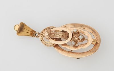 a close up of a gold pendant on a white surface
