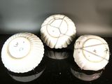 three white plates sitting on a black counter top
