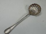a silver spoon with a shell shaped handle on a table