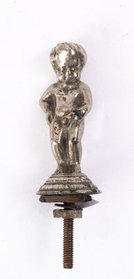 une petite figurine en argent posée au sommet d'un poteau métallique