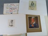 several framed and unframed drawings of people and animals on a table