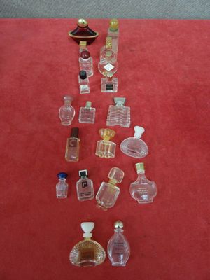 de nombreux petits flacons de parfum posés sur un support rouge