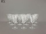 six verres à vin transparents alignés en rang sur une table
