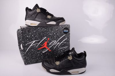 une paire de baskets noires et blanches posée sur une boîte