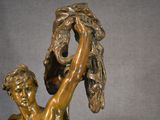 bronze statue of a boy holding a bird in his hand