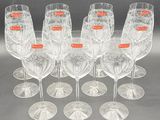 six clear wine glasses are lined up on a table