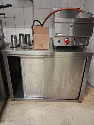 une petite cuisine équipée d'appareils électroménagers en inox et d'un sac en papier posé sur le plan de travail